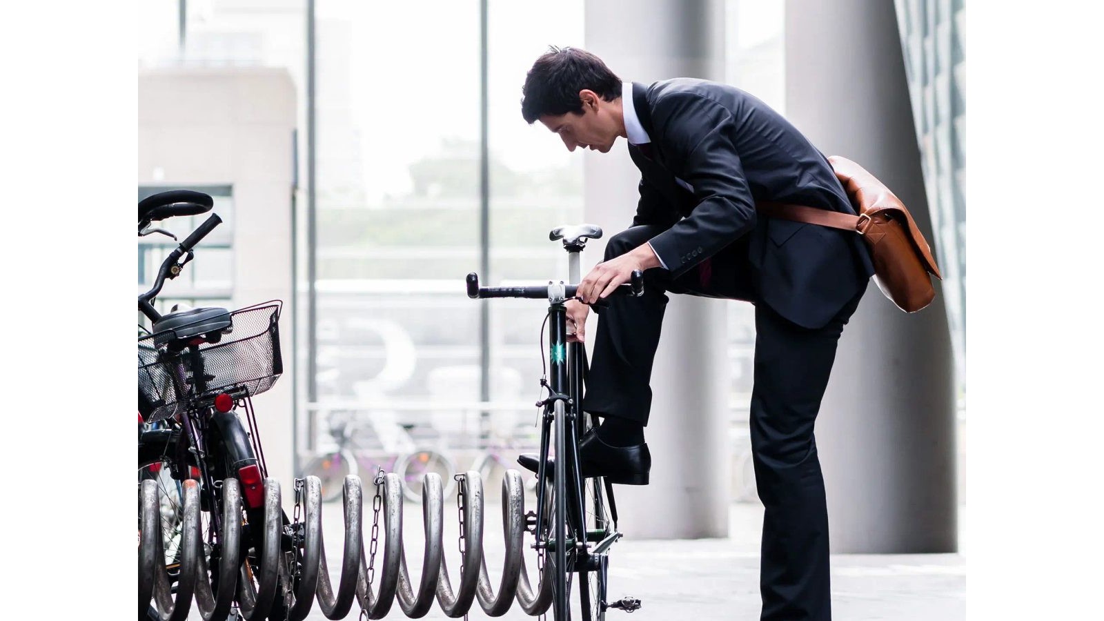 Salarié qui gare son vélo devant son bureau